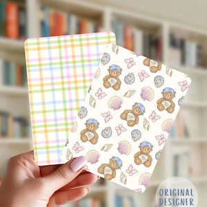 May include: Two rectangular cards. One has a pastel plaid pattern in pink, yellow, green, and blue. The other card has a cream background with a repeating pattern of teddy bears, seashells, and butterflies. The text "ORIGINAL DESIGNER" is visible.