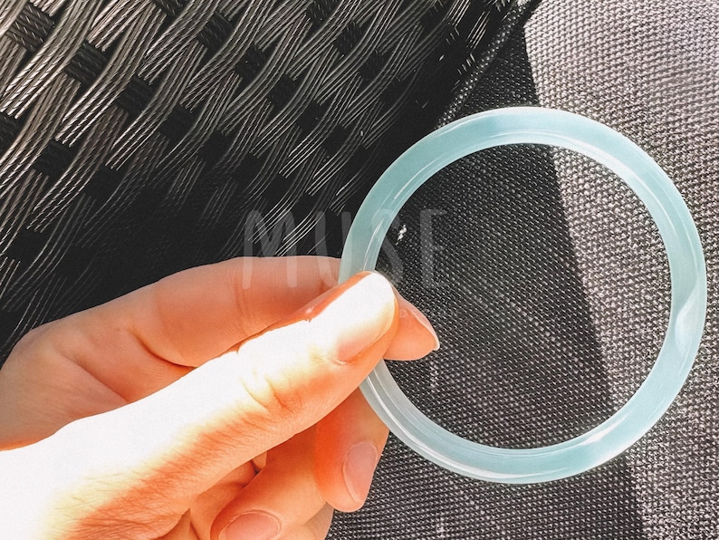 K&ouml;nnte beinhalten: Ein hellblauer Silikonring, der in einer Hand gehalten wird.