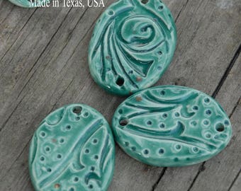 3 oval beads in teal in the whimsy pattern