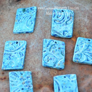 May include: Seven blue ceramic rectangular tiles with a white and gold speckled glaze and a swirl design. The tiles have a hole at the top for hanging. www.CapturedMoments.Etsy.com Made in Texas, USA