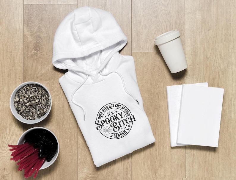 K&ouml;nnte beinhalten: Wei&szlig;er Kapuzenpullover mit einem schwarzen Kreis-Motiv, auf dem "Move Over Hot Girl Summer It's Spooky Bitch Season" steht.