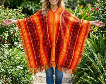 May include: A vibrant, fringed poncho in shades of orange, red, and yellow. The poncho features a geometric pattern and vertical stripes. The image also shows blue jeans and brown boots. The text "INCASTREASURES www.incastreasures.com" is visible.