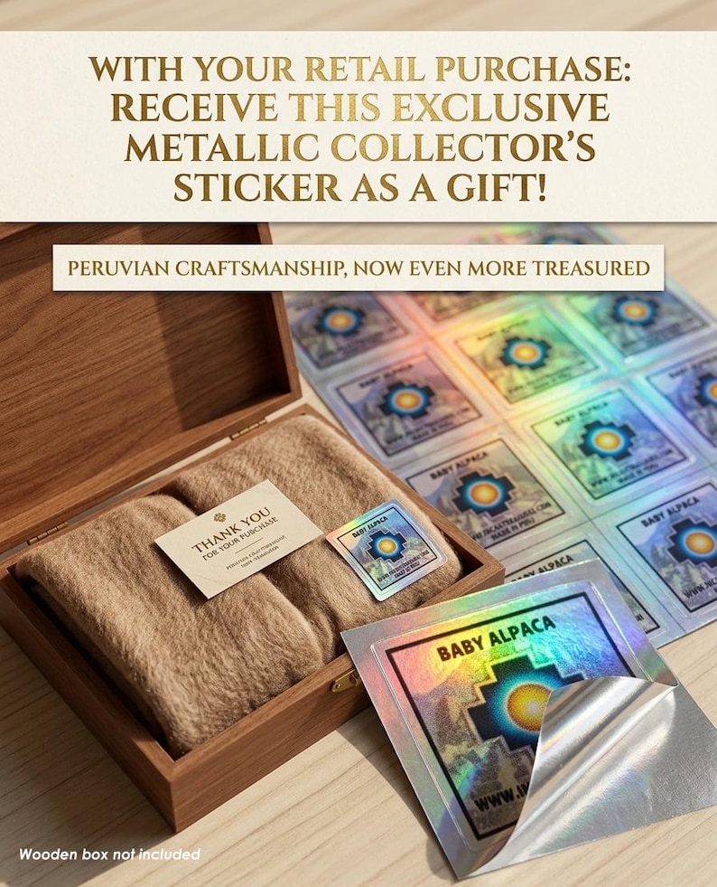 May include: A wooden box containing two beige alpaca wool items, a thank you card, and a metallic Baby Alpaca sticker. A sheet of holographic stickers is visible. Text on the image reads: "WITH YOUR RETAIL PURCHASE: RECEIVE THIS EXCLUSIVE METALLIC COLLECTOR'S STICKER AS A GIFT!" and "PERUVIAN CRAFTSMANSHIP, NOW EVEN MORE TREASURED."