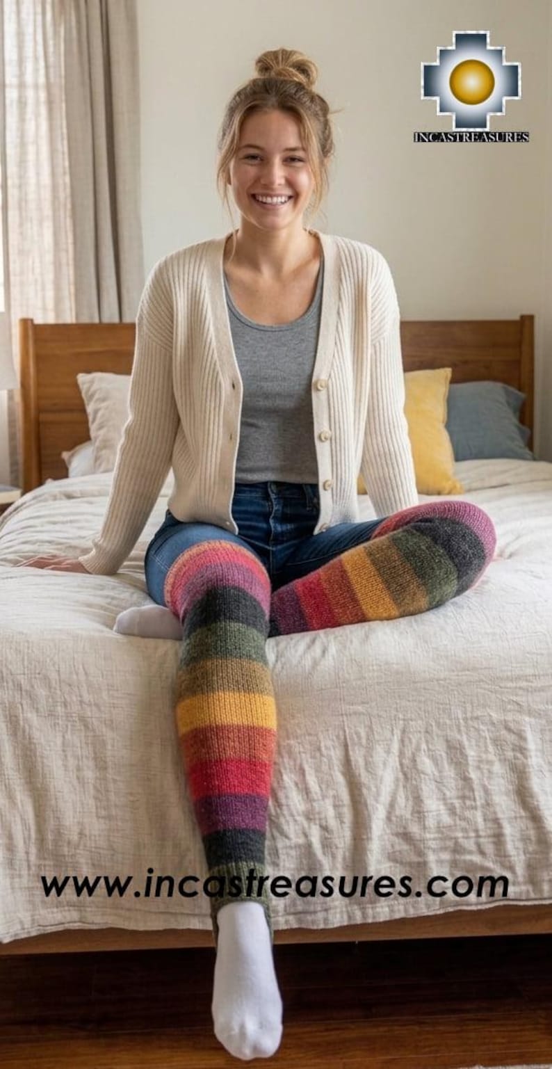 May include: A pair of over-the-knee knit leg warmers featuring horizontal stripes in shades of dark gray, olive green, yellow, red, and purple. The leg warmers have a stirrup design at the bottom and are worn over blue jeans. The text www.incastreasures.com is visible.