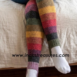 May include: Thigh-high stirrup leg warmers featuring horizontal stripes in shades of red, yellow, green, purple, and charcoal gray. The knit fabric has a ribbed texture at the top and bottom openings. The text www.incastreasures.com is visible.