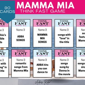 Pode incluir: Um conjunto de 90 cartas para um jogo Mamma Mia Think Fast. As cartas são rosa e azul com as palavras "Think Fast" e "Mamma Mia" nelas. Cada carta tem uma pergunta diferente sobre o filme Mamma Mia.
