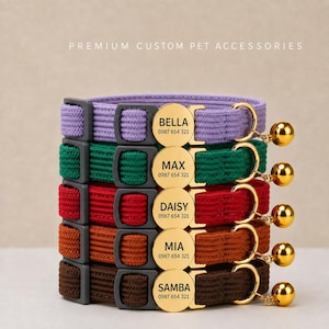 May include: A stack of five woven pet collars in lavender, green, red, orange, and brown. Each collar features a dark gray plastic buckle, a gold-toned circular metal ID tag engraved with a name and phone number, and a small gold-toned bell.