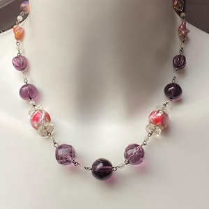 Vintage art deco 1920s mixed pressed and lampwork glass bead necklace, beads interspersed along a linked brass chain, secure hook fastener