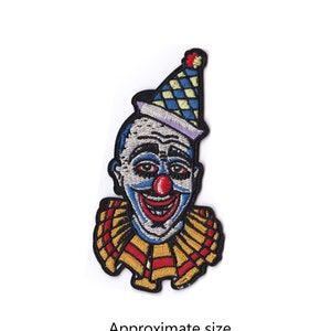 May include: Embroidered iron-on patch featuring a vintage-style clown with a red nose and a blue, yellow, and white checkered hat. The patch is approximately 4.75 inches by 2.5 inches.