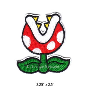May include: A red and white Piranha Plant from the Super Mario Bros. video game series. The plant has a large, open mouth with sharp teeth and is surrounded by green leaves. The patch is 2.25 inches by 2.5 inches.
