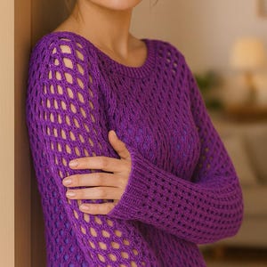 May include: A striking purple open-weave jumper with long sleeves. The jumper has a distinctive net-like design on the upper sleeves and a denser knit on the lower sleeves and body. The garment is made of a soft, textured material.