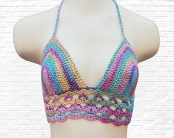 Puede incluir: Un top halter de crochet arcoíris con un borde inferior festoneado. El top está hecho con una variedad de colores, incluyendo rosa, azul, verde y amarillo.