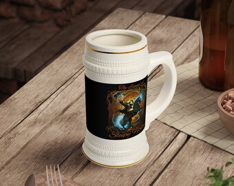 May include: White ceramic beer stein with a gold rim and a black and orange graphic of a character riding a horse. The graphic includes the text "The Legend of Sleepy Hollow".