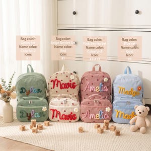 May include: Four sets of corduroy backpacks and lunch bags in green, beige with strawberry print, pink with strawberry print, and blue. Each bag features embroidered names in colorful, red, pink, or gold thread and a small flower accent.