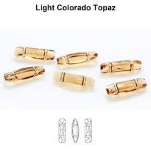 May include: Six light brown faceted glass beads with a rectangular shape. The beads have a slightly curved shape and a textured surface.