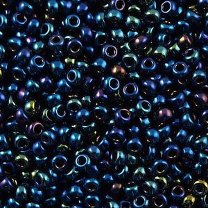 May include: A close-up view of a large quantity of dark blue seed beads with a metallic iridescent finish.