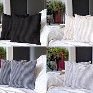 May include: Four sets of two decorative throw pillows. The pillows are made of a soft, textured fabric with a corduroy-like appearance. The pillows are shown in four different colors: black, beige, gray, and white.