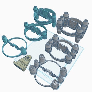 May include: Five 3D printed models of a spaceship with multiple engines. The models are in various positions and are printed in a light blue color.