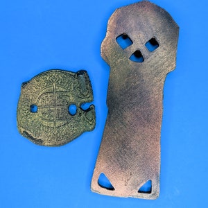 a back view of the copper bones key and doubloon against a blue background