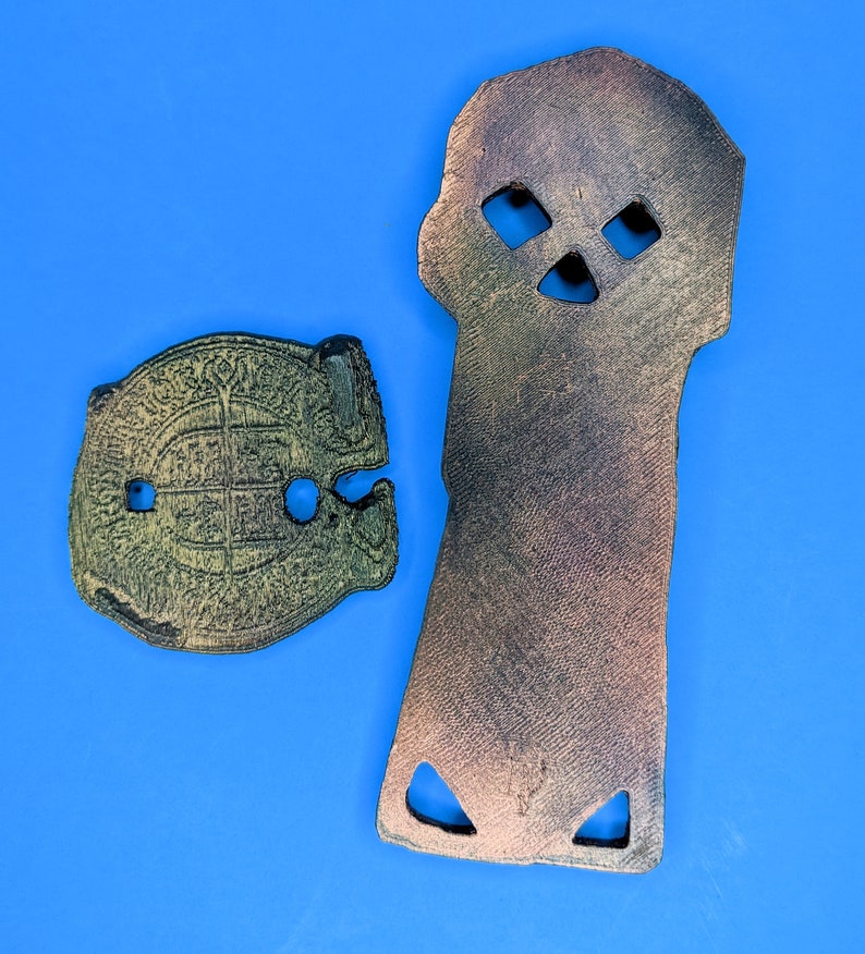 a back view of the copper bones key and doubloon against a blue background