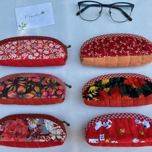 K&ouml;nnte beinhalten: Sechs halbkreisf&ouml;rmige Stoffetuis mit den Nummern 44 bis 49, mit verschiedenen Mustern wie Blumen, Libellen, Herbstbl&auml;ttern und Zeichentrickfiguren. Jedes Etui verf&uuml;gt &uuml;ber einen Rei&szlig;verschluss und ein strukturiertes, gestepptes Basisdesign.