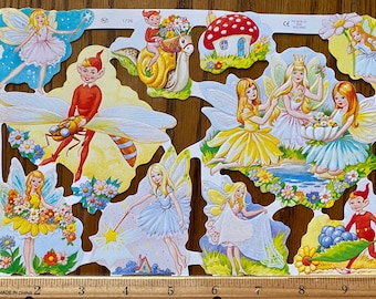 Puede incluir: Una hoja de recortes de papel de colores con hadas, gnomos y otros personajes fantásticos. Las hadas están vestidas de varios colores, incluyendo azul, amarillo y blanco. Los gnomos llevan atuendos rojos y verdes. Los recortes son perfectos para añadir un toque de magia a cualquier proyecto de manualidades.