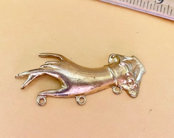 Könnte beinhalten: Ein goldfarbener Metall-Hand-Anhänger mit detailliertem Design. Die Hand ist offen, die Finger sind ausgestreckt und der Daumen zeigt zur Handfläche. Der Anhänger hat drei kleine Schlaufen zum Anbringen an einer Halskette oder einem Armband.
