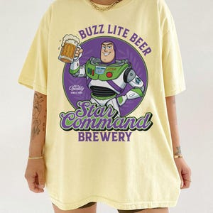 May include: A set of three ceramic mugs with a speckled, cream-colored glaze. Each mug features a different hand-painted design: a blue and green leaf, a yellow flower, and a red berry. The mugs have a simple, modern design.