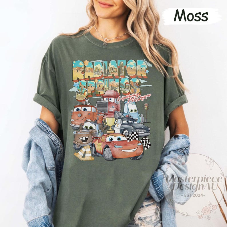 May include: A green t-shirt with a vintage-style graphic of the Cars characters from the Disney Pixar movie Cars. The graphic features the text "Radiator Springs" and "Lightning McQueen".