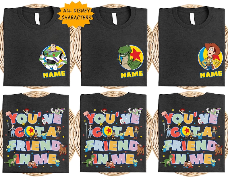 May include: Black t-shirts featuring Toy Story characters. Some shirts show Buzz Lightyear, Rex, or Woody with the text NAME. Others display the text YOU'VE GOT A FRIEND IN ME surrounded by various Toy Story character illustrations and stars.