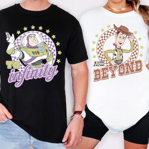 May include: Black and white t-shirts featuring cartoon characters Buzz Lightyear and Woody from Toy Story. Buzz Lightyear's shirt says "To Infinity" and Woody's shirt says "And Beyond". Both shirts have a circular design with stars.