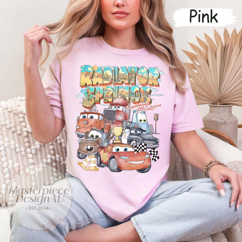 May include: Pink t-shirt with a graphic of the Cars characters from the movie Cars. The graphic includes the text "Radiator Springs" and "Lightning McQueen".