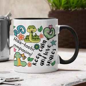 May include: A white ceramic mug with a black handle and the text "But First, Coffee" in a handwritten style. The mug is likely 325 ml in size, ideal for a morning beverage.