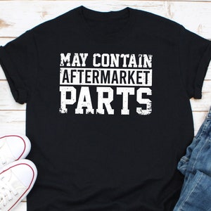 Könnte beinhalten: Schwarzes T-Shirt mit weißem Text, der "May Contain Aftermarket Parts" lautet.