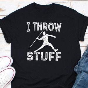 Puede incluir: Camiseta negra con el texto blanco "I THROW STUFF" y un gráfico blanco de un lanzador de jabalina. La camiseta tiene mangas cortas y cuello redondo.