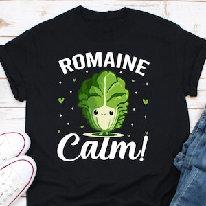 Könnte beinhalten: Schwarzes T-Shirt mit einer weißen Grafik einer Cartoon-Römersalat mit dem Text "Romaine Calm!"