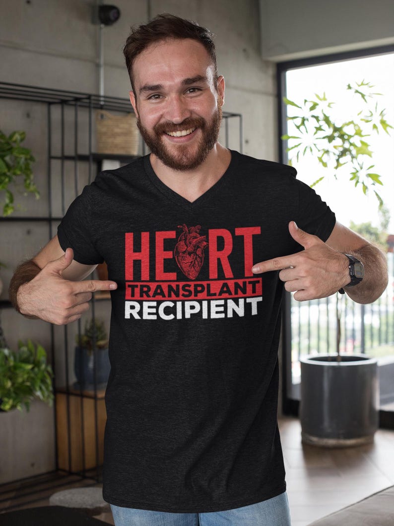 May include: A black V-neck t-shirt with the text "HEART TRANSPLANT RECIPIENT" in red letters. A red anatomical heart graphic is centred above the text.