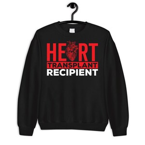 May include: Black sweatshirt with red text that reads "HEART TRANSPLANT RECIPIENT" with a red anatomical heart graphic.