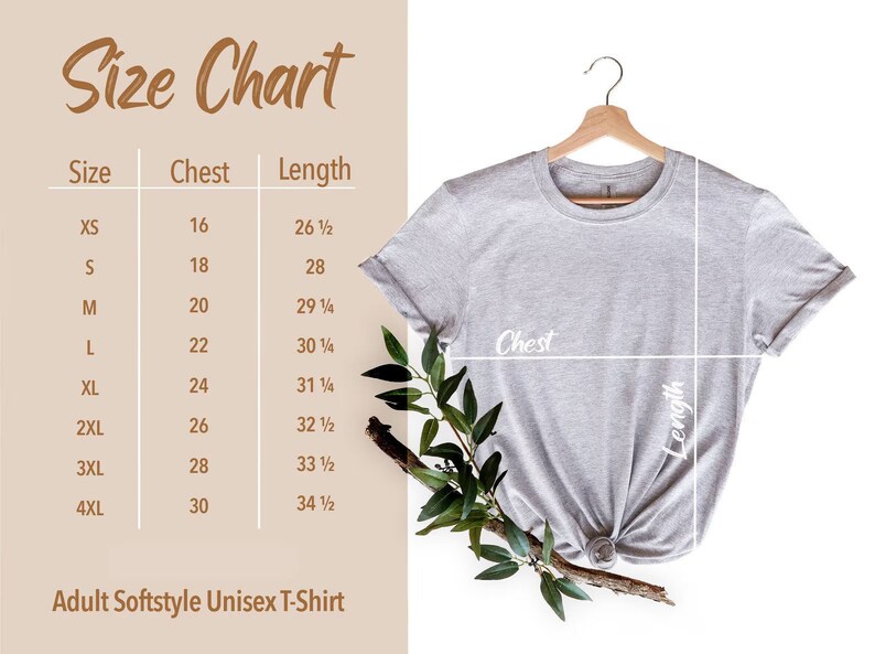 May include: A light gray Adult Softstyle Unisex T-Shirt hangs on a wooden hanger. A size chart shows chest and length measurements in inches for sizes XS to 4XL. The chart is next to the shirt.