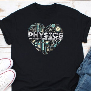 Puede incluir: Camiseta negra con un diseño en forma de corazón lleno de ilustraciones relacionadas con la física. La palabra "PHYSICS" se muestra de forma destacada, con la frase "WHY STUFF DOES OTHER STUFF" debajo. El diseño incorpora herramientas y símbolos científicos.