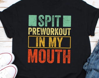 Könnte beinhalten: Schwarzes T-Shirt mit einem Vintage-Grafikdruck, auf dem "Spit Preworkout In My Mouth" steht.