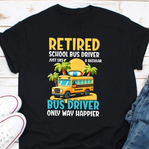 May include: Black t-shirt with a graphic featuring a yellow school bus, palm trees, and a sun. Text reads "Retired School Bus Driver" and "Bus Driver Only Way Happier."
