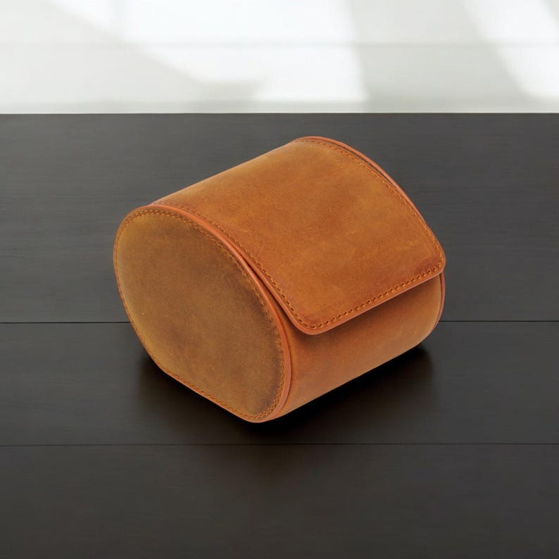 May include: A brown leather watch roll for storing and protecting watches.