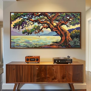 May include: A large framed painting depicts a vibrant tree with a sprawling trunk and branches, set against a backdrop of a lake and mountains. The artwork is displayed above a wooden cabinet with a record player and a small radio.