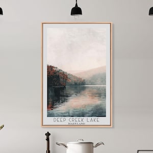 May include: A framed print of a scenic landscape featuring a lake surrounded by trees with fall foliage. The text "DEEP CREEK LAKE MARYLAND" is at the bottom of the print.