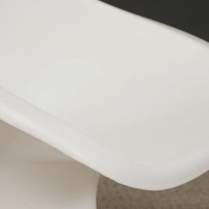 May include: A modern, white, molded plastic chair with a curved seat and a pedestal base. The chair has a smooth, glossy finish and a minimalist design, suitable for various interior styles.