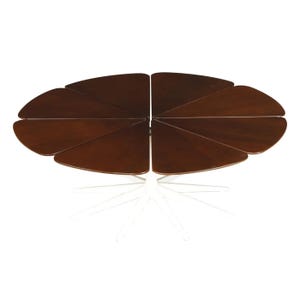 May include: Oval-shaped, dark brown wooden table with a unique design. The tabletop is composed of multiple triangular sections. The table rests on a white, starburst-style base, creating a modern aesthetic. The table is approximately 60 inches long.
