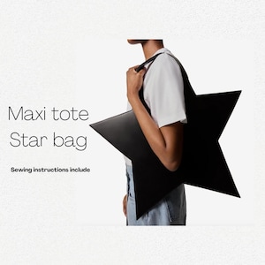 Peut inclure: Un sac cabas noir en forme d'étoile avec une grande poignée. Le texte "Maxi tote Star bag" et "Sewing instructions include" est visible sous le sac.