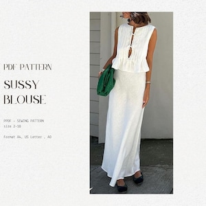May include: A white sleeveless blouse with a tie detail at the neckline. The blouse has a ruffled hem and is paired with a white maxi skirt. The text "PDF PATTERN SUSSY BLOUSE" is visible at the top of the image. The text "PPDF - SEWING PATTERN size 2-18 Format A4, US Letter, AO" is visible at the bottom of the image.