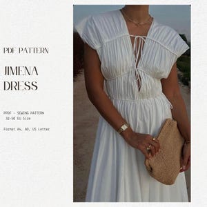 May include: A white dress with a V-neckline and a tie at the neckline. The dress has a gathered bodice and a flowing skirt. The dress is shown on a model with a straw bag.